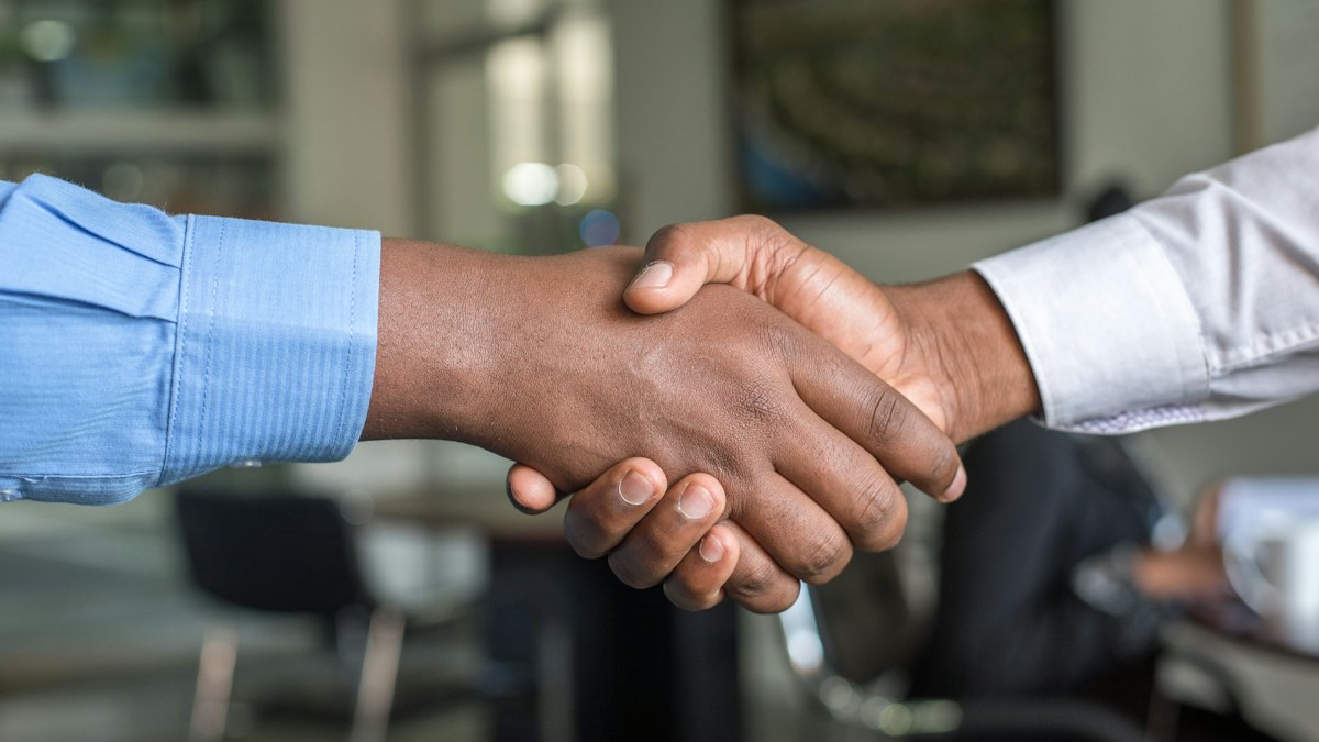 Poignée de main entre deux personnes en tenue professionnelle