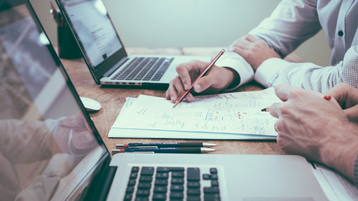 Réunion de travail avec ordinateurs portables, carnet et stylo